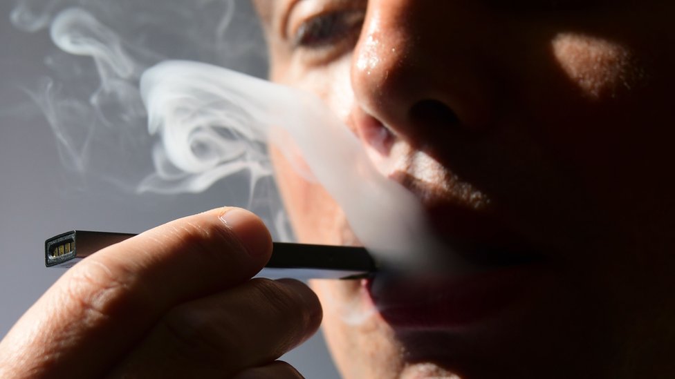 In this file illustration taken on October 02, 2018, a man exhales smoke from an electronic cigarette in Washington, DC.